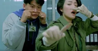 A screen shot taken from the 1993 horror film, The Untold Story. It shows two police officers holding their noses.