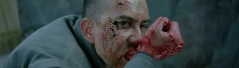 A screen shot taken from the 1993 horror film, The Untold Story. It shows the main character chewing through his wrist.